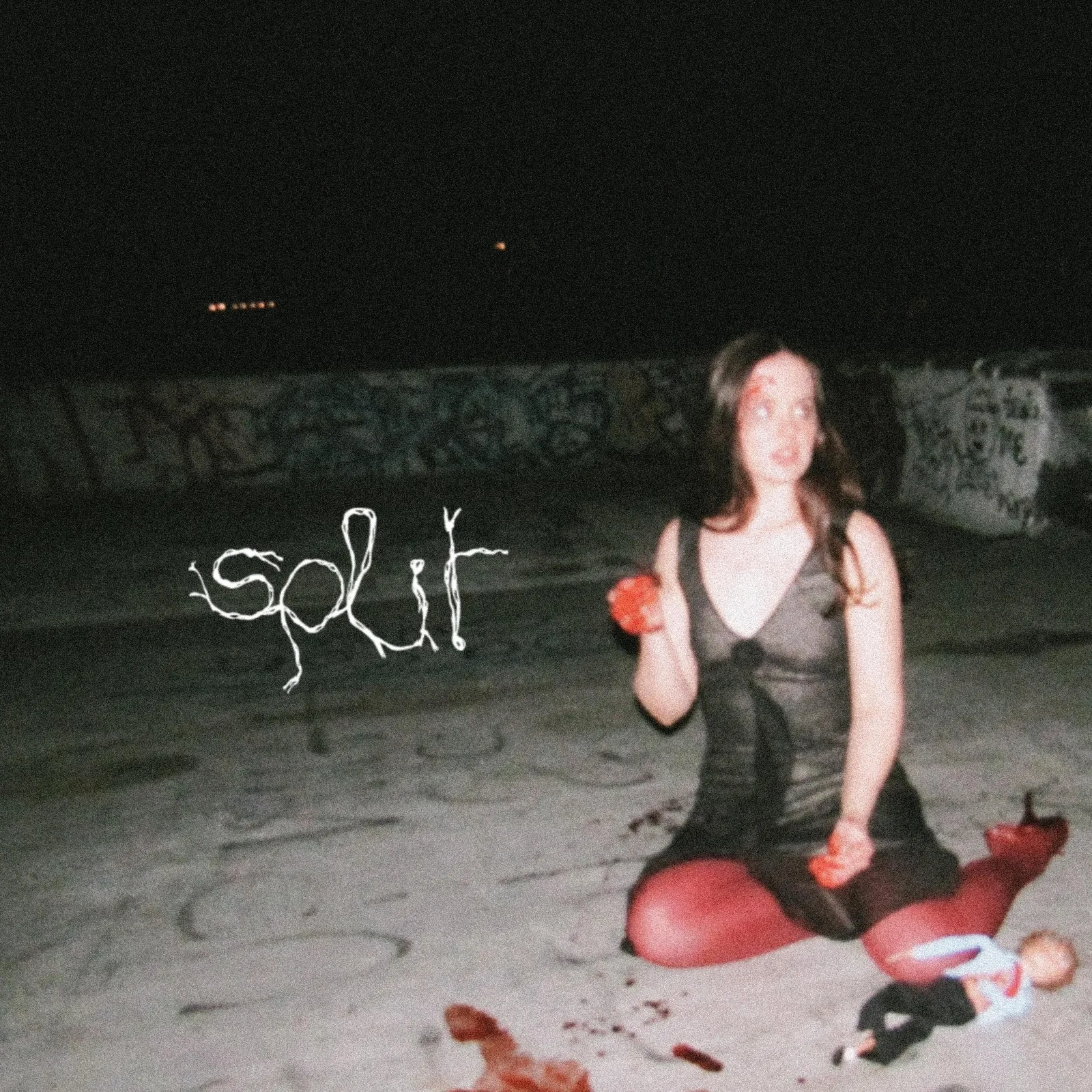 A woman sat on the ground, next to text "Split"
